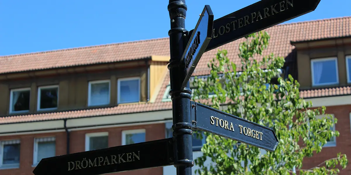 Foto på skyltar i Enköping som visar vägen till torget, Klosterparken och Dtömparken.