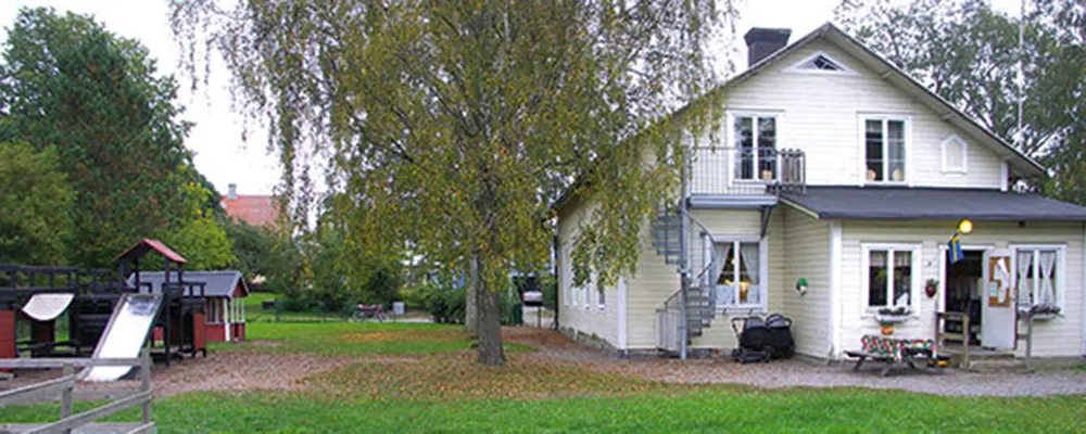 Foto av förskolan Paletten Skolsta. Det är ett vitt trähus. 